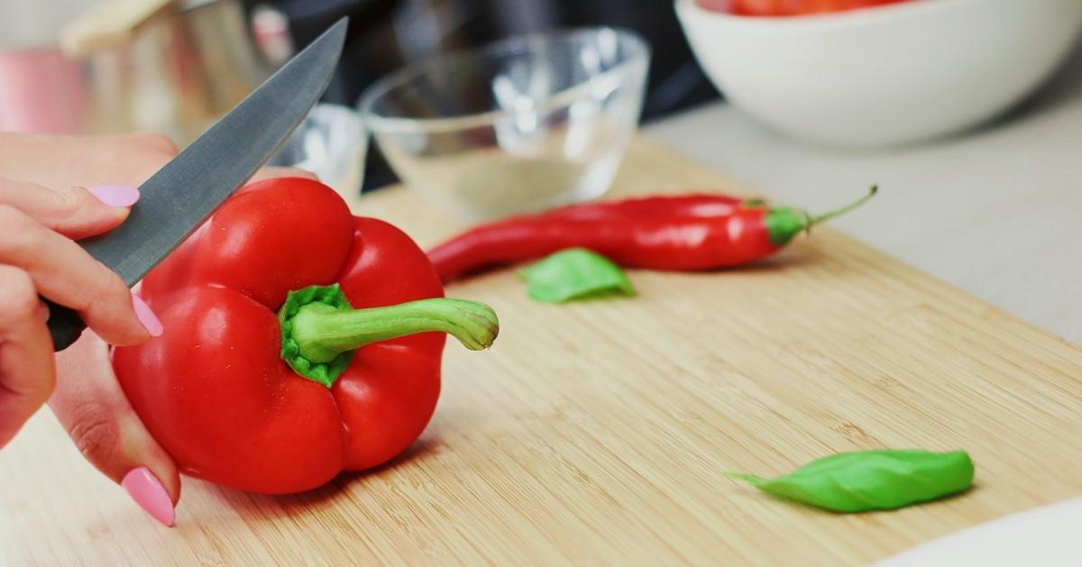 händer som skär en paprika med vass kniv